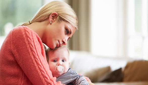 Femme tenant son bébé et se questionnant sur la fibre maternelle, le lien parent-enfant et les attentes sociales