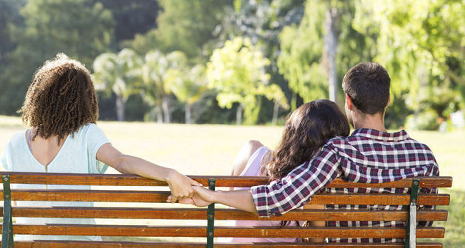 Infidélité - femme seule sur un banc regardant un couple se tenir la main