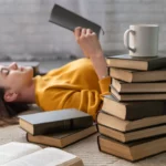 Entourée de livres, elle plonge dans sa lecture avec sérénité — un moment de pause inspirant, entre détente et croissance intérieure | labonnecopine.com