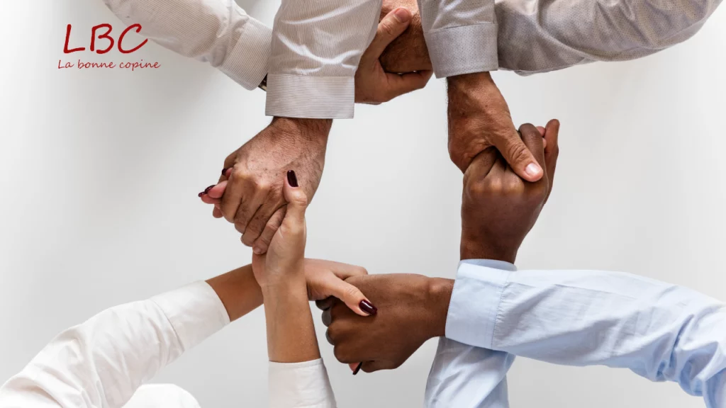Union de plusieurs mains aux origines ethniques variées évoque la force de la solidarité et l’importance de la collaboration entre les cultures | labonnecopine.com