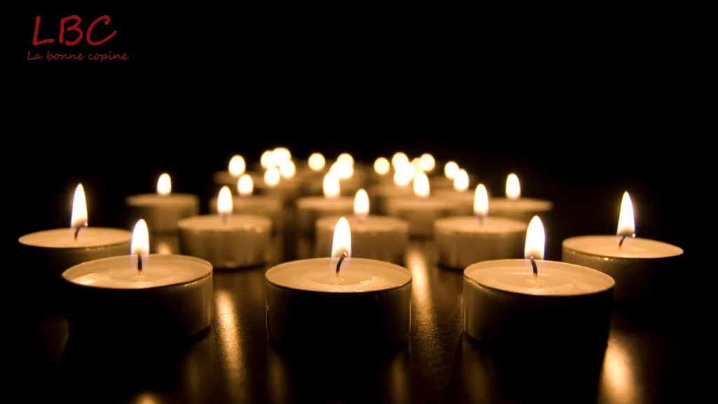 Des bougies allumées illuminent l'obscurité, diffusant une atmosphère calme et solennelle | labonnecopine.com