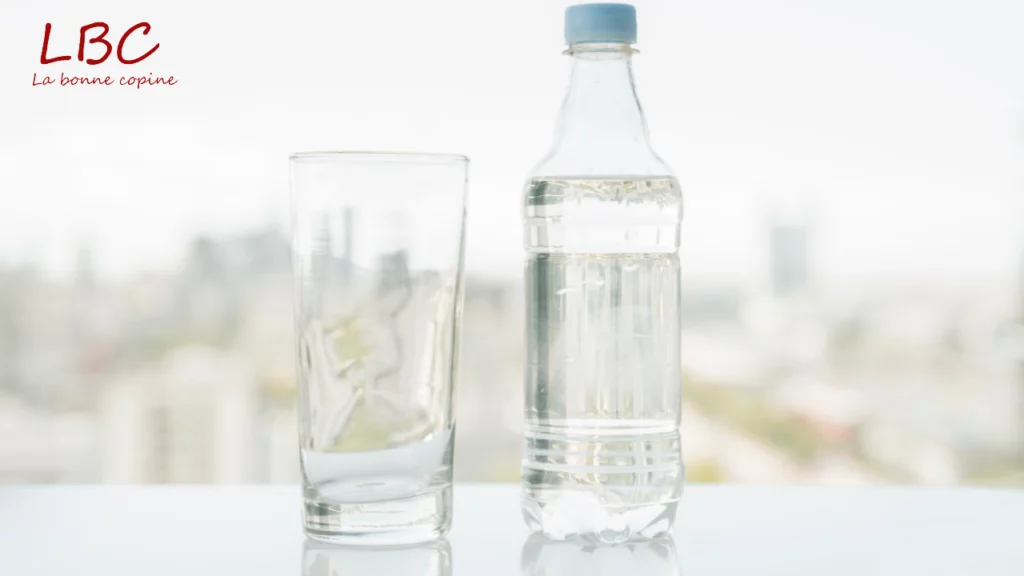 Waterfles naast een leeg glas, symbool voor hydratatie en een gezonde routine