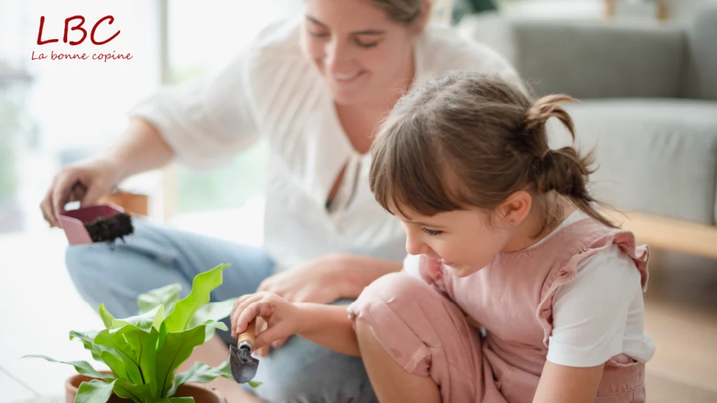 A sunlit living room where a mother shares a tender moment with her daughter while caring for a green plant, hand in hand with nature | labonnecopine.com