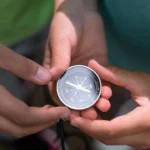 Main dans la main, deux personnes guident une boussole, symbole d’un chemin choisi ensemble. Ce geste évoque la co-navigation, la confiance mutuelle et l’importance d’avancer à deux vers une direction commune, portée par l’écoute et l’alignement intérieur | labonnecopine.com