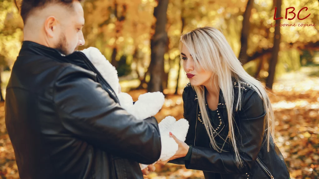 In an autumn‑colored park, two couples gently cradle a baby, offering affectionate gestures and smiling, creating a warm, tender atmosphere