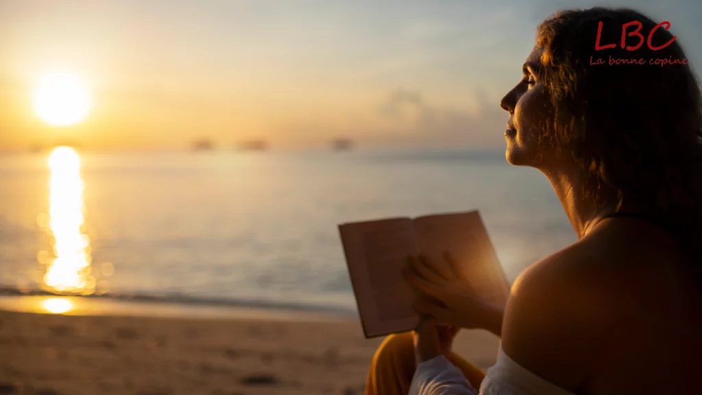 Personne lisant un livre sur la plage au coucher du soleil | labonnecopine.com