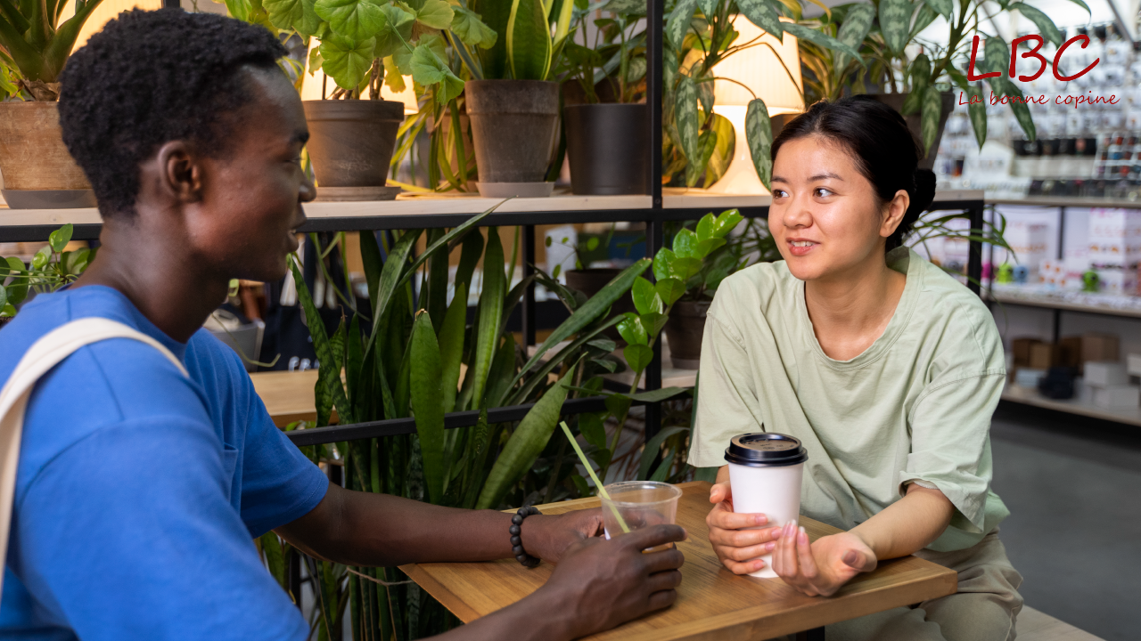 In a cozy, plant‑filled café two people converse with gentle attention, exemplifying active listening—a key pillar of nonviolent communication where every word is received with respect and empathy.