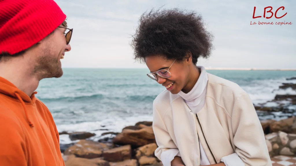 Dans le cadre apaisant du bord de mer, un sourire sincère accompagne un léger mouvement vers l’autre, une belle scène de connexion et d’écoute | labonnecopine.com
