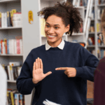 Dans une bibliothèque, la langue des signes devient le pont entre les individus, illustrant la richesse d'une communication au-delà des mots | labonnecopine.com