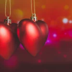 Illuminés par une lueur chaleureuse, deux cœurs rouges suspendus incarnent l’union et la complicité | labonnecopine.com