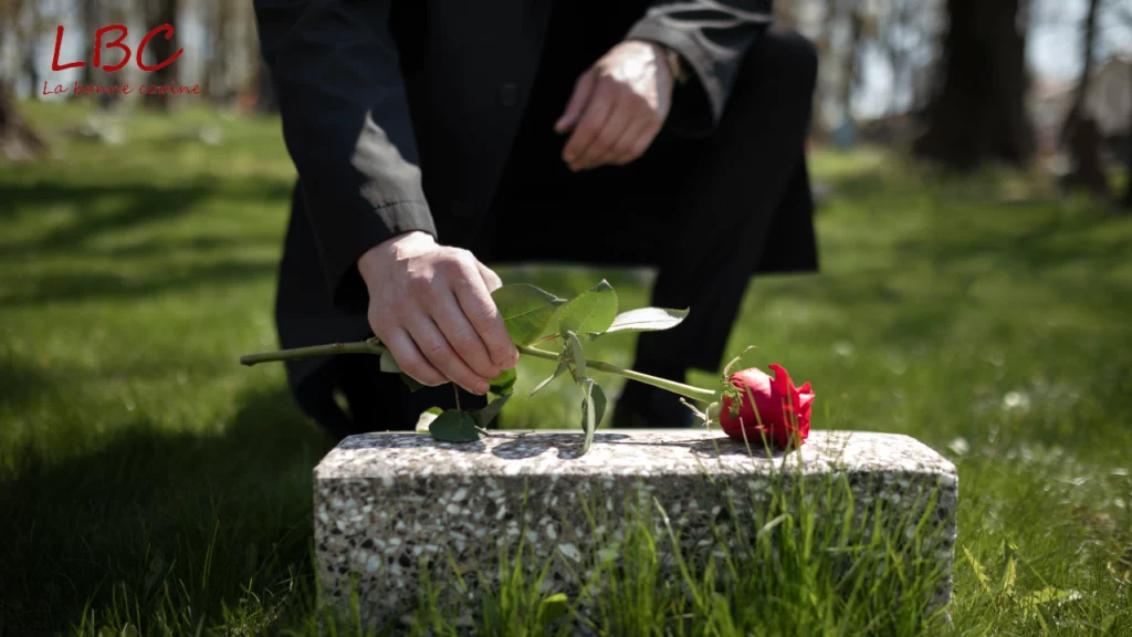 Une rose rouge est déposée sur une tombe, en signe de recueillement silencieux | labonnecopine.com