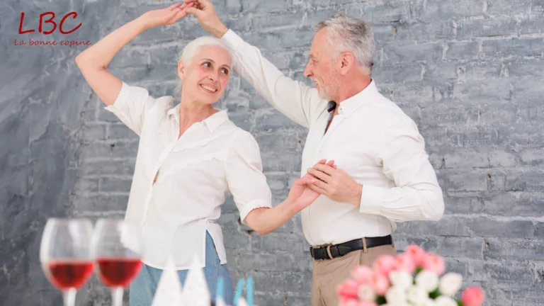 Dans une ambiance chaleureuse et festive, un couple senior partage un moment de danse complice, mêlant joie, tendresse et vitalité. Une scène qui illustre la beauté de l’amour et de la légèreté à tout âge | labonnecopine.com