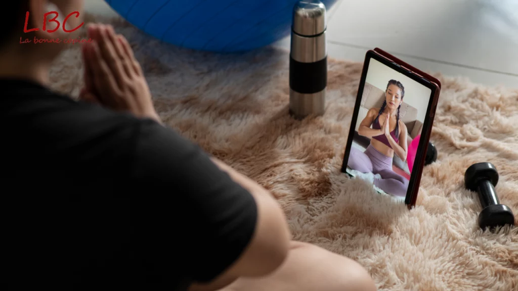 A remote yoga session on a mat, guided via video call, with dumbbells and a water bottle nearby, illustrating a well‑rounded practice