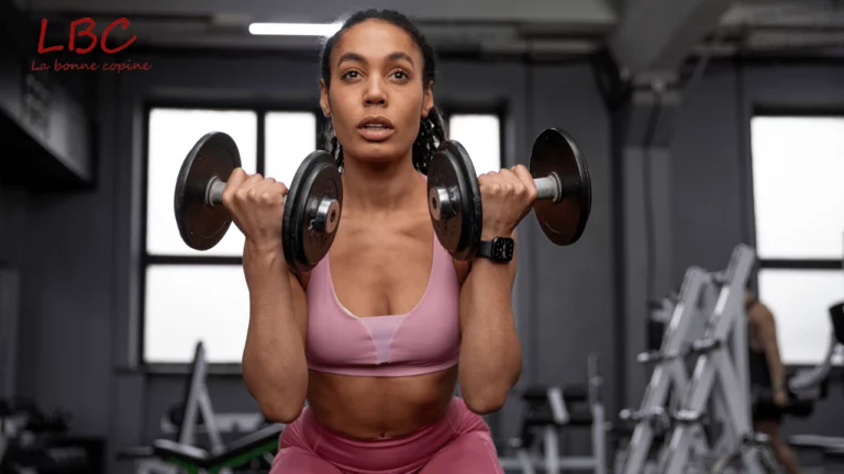 A woman in pink sportswear performs dumbbell curls in a modern weight room | labonnecopine.com/en