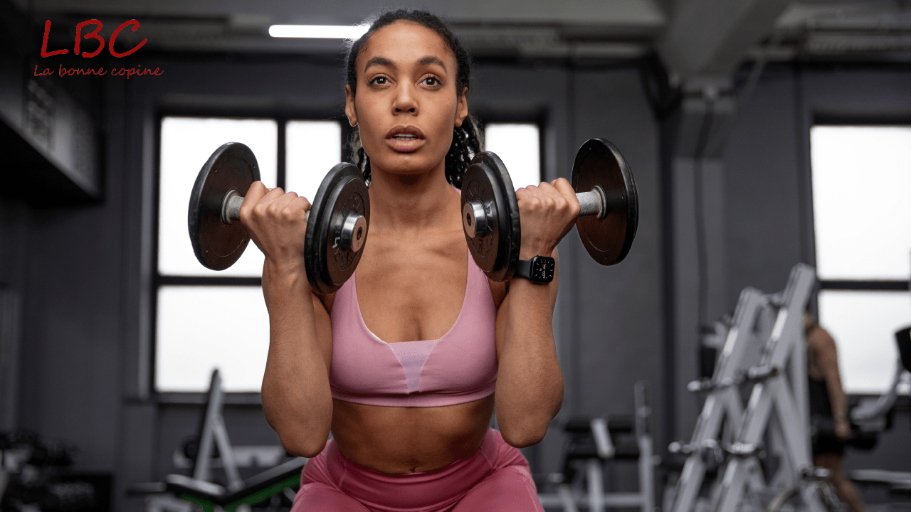 A woman in pink sportswear performs dumbbell curls in a modern weight room | labonnecopine.com/en