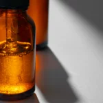 Flacon en verre ambré rempli d'un liquide orange, avec une pipette | labonnecopine.com