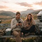 Couple en road trip dans les montagnes avec un van et des téléphones | LBC